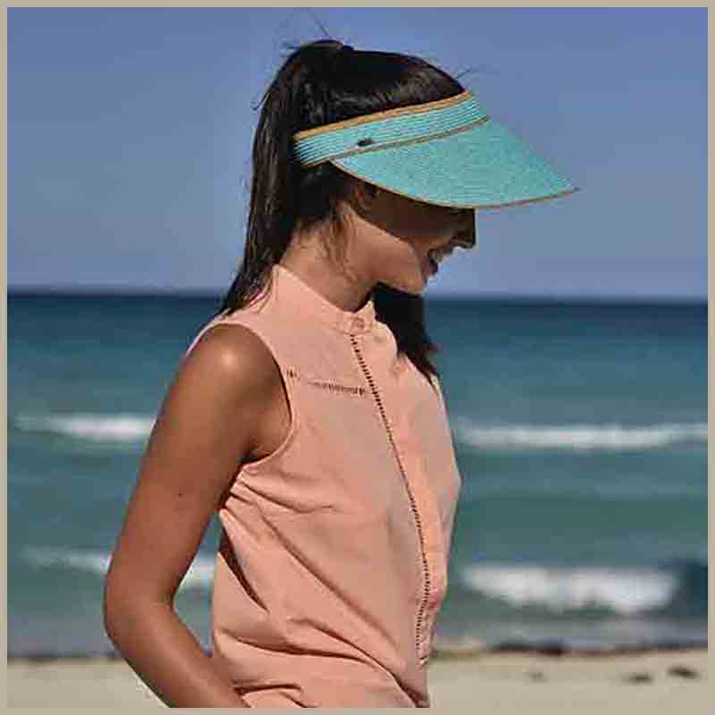 Women's sun visors. Large variety of straw and cotton sun visor. Black laichow straw sun visor on model on beach