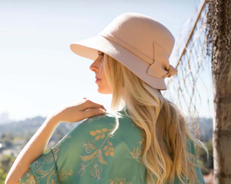 Bring back the early 20th century when this feminine hat style swept through the world. Women in deep bell shape cloche hat glancing into the far