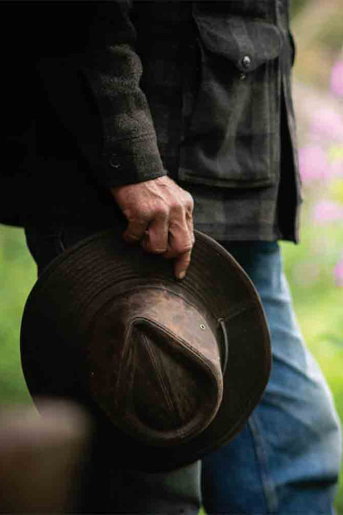 Image of a man holding a waxed cotton safari hat