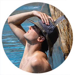 evaporative cooling soaker hat on man under waterfall